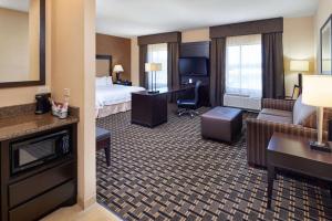 a hotel room with a bed and a living room at Hampton Inn & Suites Longview North in Longview