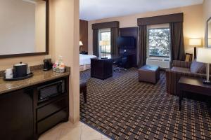 Habitación de hotel con cama extragrande y sala de estar. en Hampton Inn & Suites Longview North, en Longview