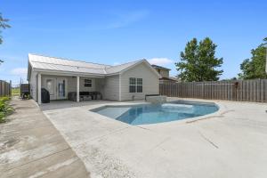 a swimming pool in front of a house at The Splash Pad Sleeps 13 w Pool Patio and Garage in Panama City
