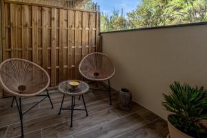 2 sillas y una mesa en el patio en Magic Surf House en Lacanau