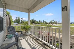 a porch with two chairs and a view of the beach at The Splash Pad Sleeps 13 w Pool Patio and Garage in Panama City
