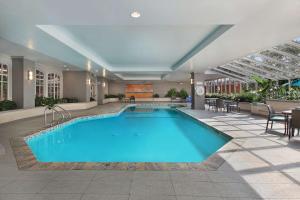 アナハイムにあるEmbassy Suites by Hilton Anaheim Northのテーブルと椅子付きのホテル内の大きなプールを提供しています。
