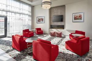 a living room with red chairs and a fireplace at Hampton Inn Long Beach Airport, Ca in Long Beach