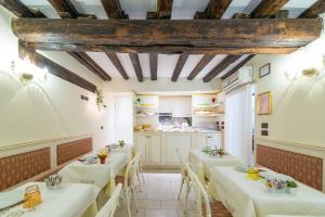 a restaurant with tables and a kitchen in the background at Locanda Ca' Zose in Venice