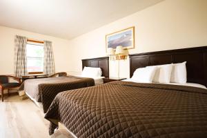 a hotel room with two beds and a window at Chatham Travel Lodge in Old Chatham