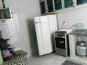 a small kitchen with a refrigerator and a stove at Pousada do Joaquimxdarc in Natal