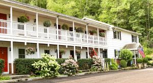 a white house with flowers and plants on it at Chatham Travel Lodge in Old Chatham