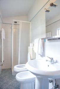 bagno bianco con lavandino e servizi igienici di Soggiorno Sogna Firenze a Firenze