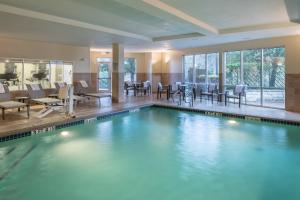 a pool in a hotel with chairs and tables at Courtyard Austin North/Parmer Lane in Austin