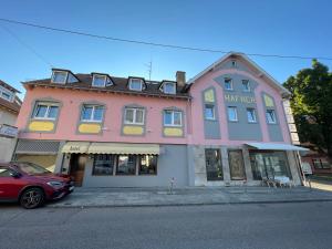 ein rosafarbenes Gebäude mit einem davor geparkt in der Unterkunft Hafner Hotel- Apartment in Stuttgart
