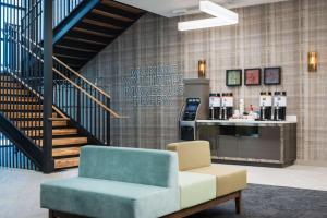a lobby with a couch and a chair and a staircase at Hampton Inn & Suites Miami Wynwood Design District, FL in Miami