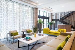 a living room with a yellow couch and a table at Hampton Inn & Suites Miami Wynwood Design District, FL in Miami