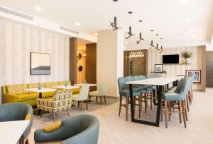 a dining room with tables and chairs and a tv at Hampton Inn & Suites Miami Wynwood Design District, FL in Miami