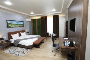 a hotel room with a bed and a desk at CHlNOR HOTEL in Andijan