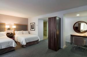 una camera d'albergo con due letti e uno specchio di Hampton Inn Manhattan - Times Square South a New York