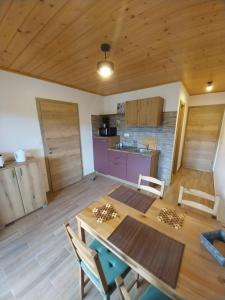 eine Küche und ein Esszimmer mit einem Holztisch und Stühlen in der Unterkunft Apartments at Klemen in Zgornje Gorje