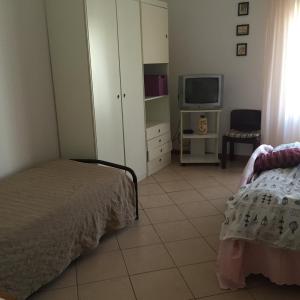 1 dormitorio con 1 cama y TV. en Welcome Traveller Borgo Cavour Apartaments, en Bardolino