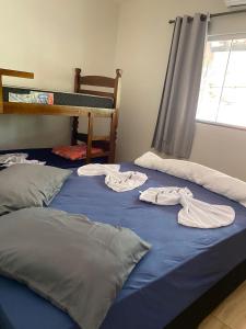 two unmade beds in a room with clothes on them at Em Busca Hostel in Bonito