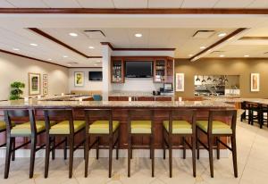 a large bar in a hotel room with stools at Hilton Garden Inn Naperville/Warrenville in Warrenville