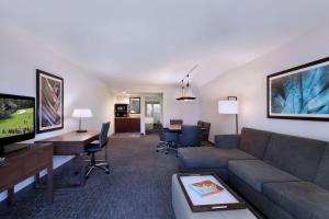 sala de estar con sofá y TV en Embassy Suites by Hilton Palm Desert en Palm Desert