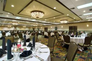 un salón de banquetes con mesas y sillas blancas en Embassy Suites by Hilton Palm Desert, en Palm Desert