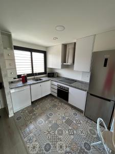una cucina con armadietti bianchi e pavimento piastrellato di La estrella de Javi a Benajarafe