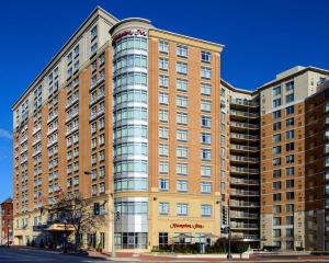 a large brick building with glass windows on a street at Hampton Inn Washington DC - Convention Center in Washington