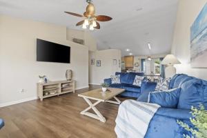 a living room with a blue couch and a tv at Escape to Paradise w Saltwater Pool 25 Min to PCB in Panama City