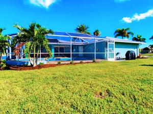 a house with a palm tree in front of it at 20 Disc-2 Kg Mstrs, Golf, Fishing, BBQ, Pool, Spa in Cape Coral +38 photos