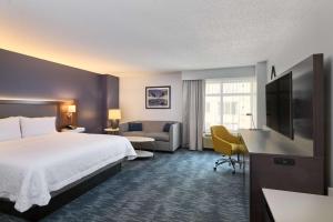 een hotelkamer met een bed, een bank en een televisie bij Hampton Inn Washington DC - Convention Center in Washington