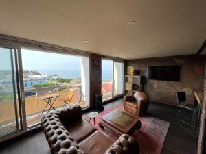 een woonkamer met een bank en een groot raam bij This one in Concarneau