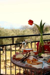 una mesa con comida y un jarrón con una flor en Residence Tre Mulini, en Scario