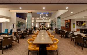 a large dining room with tables and chairs at Hilton Garden Inn Lake Forest Mettawa in Lake Forest
