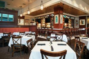 un restaurante con mesas y sillas blancas y un bar en Hilton Garden Inn Washington DC/Georgetown Area en Washington