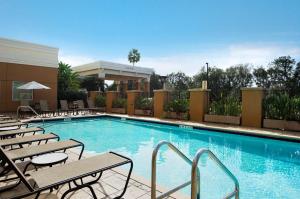 a large swimming pool with chairs and a hotel at Embassy Suites by Hilton Tampa Brandon in Tampa