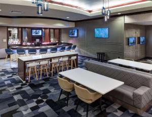 a restaurant with a bar with tables and chairs at Embassy Suites by Hilton Tampa Brandon in Tampa