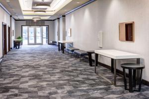 a waiting room with tables and stools in a building at Embassy Suites by Hilton Tampa Brandon in Tampa