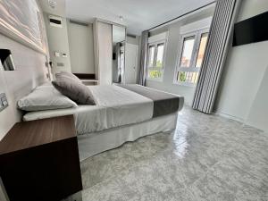 a bedroom with a large bed and windows at Hotel El Paraíso in Calabardina