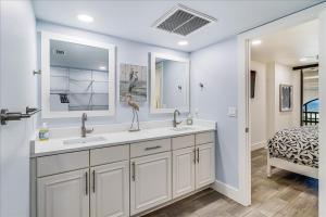 a bathroom with two sinks and a bed in a room at 8th Floor Penthouse Luxury Beautifully Remodeled in Port Aransas +43 photos