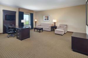 a hotel room with a desk and a couch and a chair at Hampton Inn & Suites Decatur in Decatur
