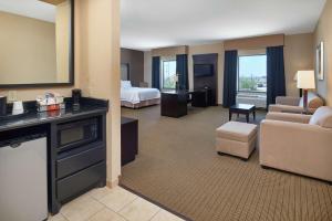 a hotel room with a bed and a living room at Hampton Inn & Suites Decatur in Decatur