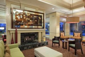 a living room with a fireplace and a tv at Hilton Garden Inn Hoffman Estates in Hoffman Estates