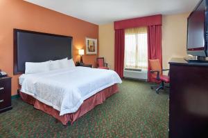 a hotel room with a bed and a flat screen tv at Hampton Inn & Suites Waco-South in Waco