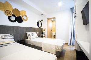 a hotel room with two beds and a tv at Mousikorama Apartments in Faliraki