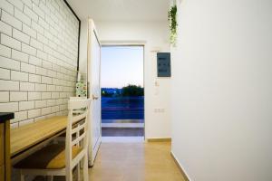 a hallway with a bench and a door with a window at Mousikorama Apartments in Faliraki