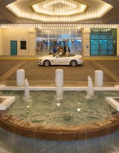 Hilton Daytona Beach Resort في دايتونا بيتش: سيارة بيضاء متوقفة في مبنى به نافورة