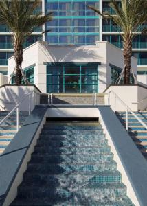 eine Treppe, die zu einem Gebäude mit Palmen führt in der Unterkunft Hilton Daytona Beach Resort in Daytona Beach