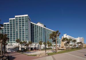 ein hohes Gebäude mit Palmen davor in der Unterkunft Hilton Daytona Beach Resort in Daytona Beach