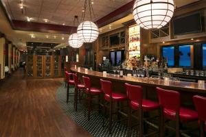 bar w restauracji z czerwonymi krzesłami i światłami w obiekcie Hilton Daytona Beach Resort w mieście Daytona Beach