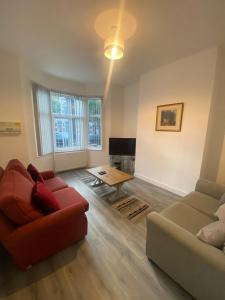 ein Wohnzimmer mit einem Sofa und einem Tisch in der Unterkunft Luxury Fully Furnished Bedroom in Leicester